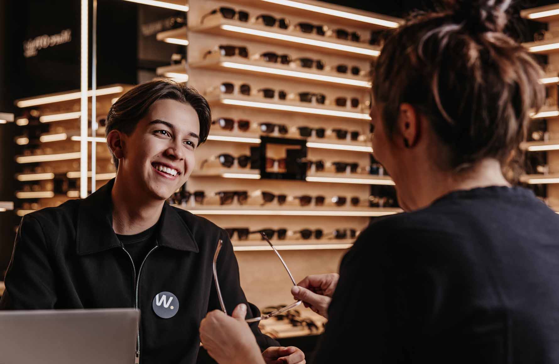 Kampagne Service Champion Dame bei der Beratung eines Kunden für den Kauf einer Brille