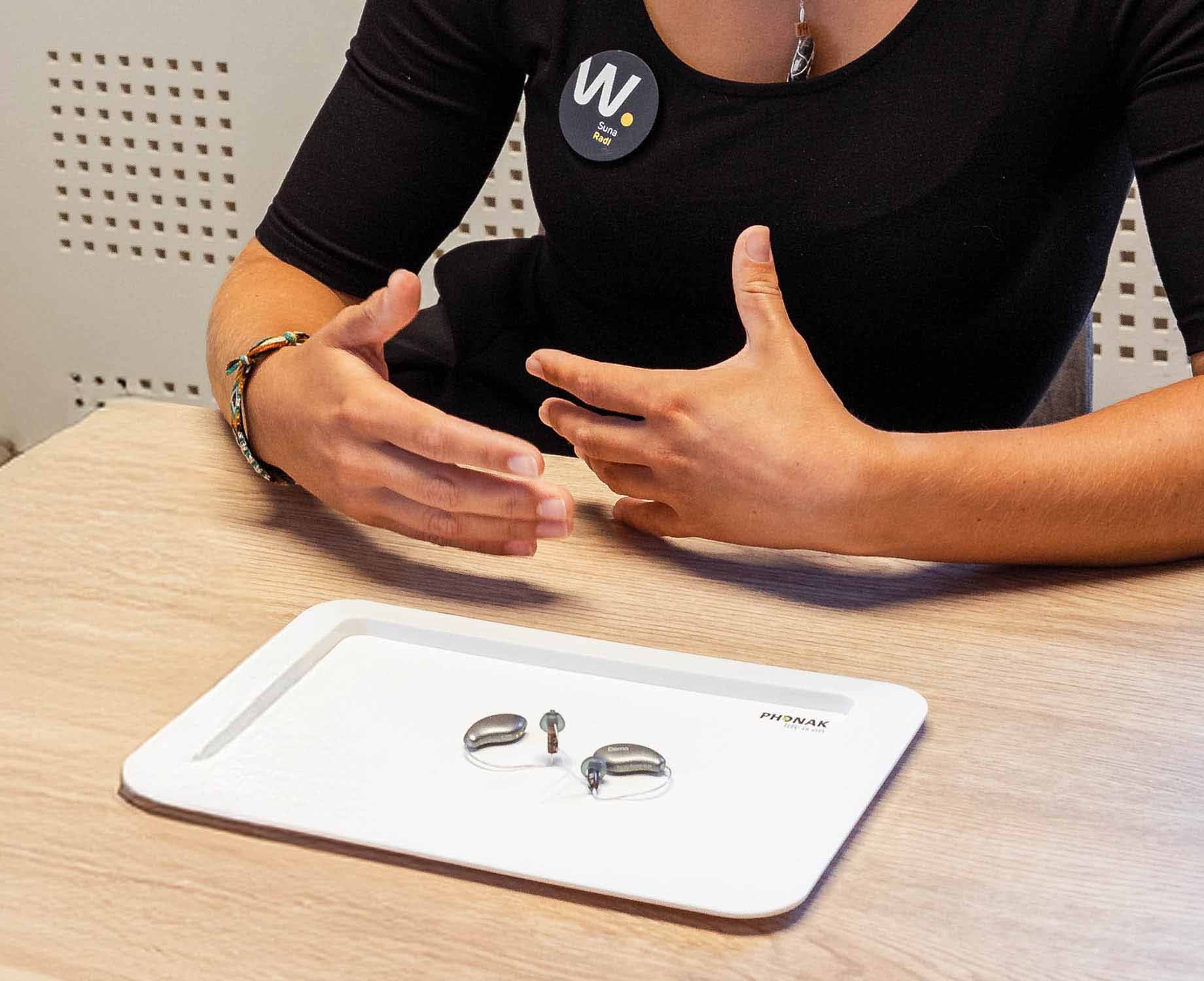 Verkäuferin bei der Erklärung eines Hörgerätes Verkäuferin bei der Erklärung eines Hörgerätes