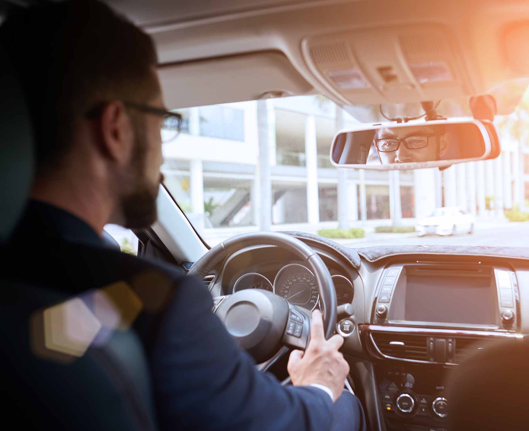 Mann lenkt ein Auto mit Brille